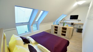 A bedroom with a bed, a desk, and a TV. - Flair Hotel Reuner (Zossen)