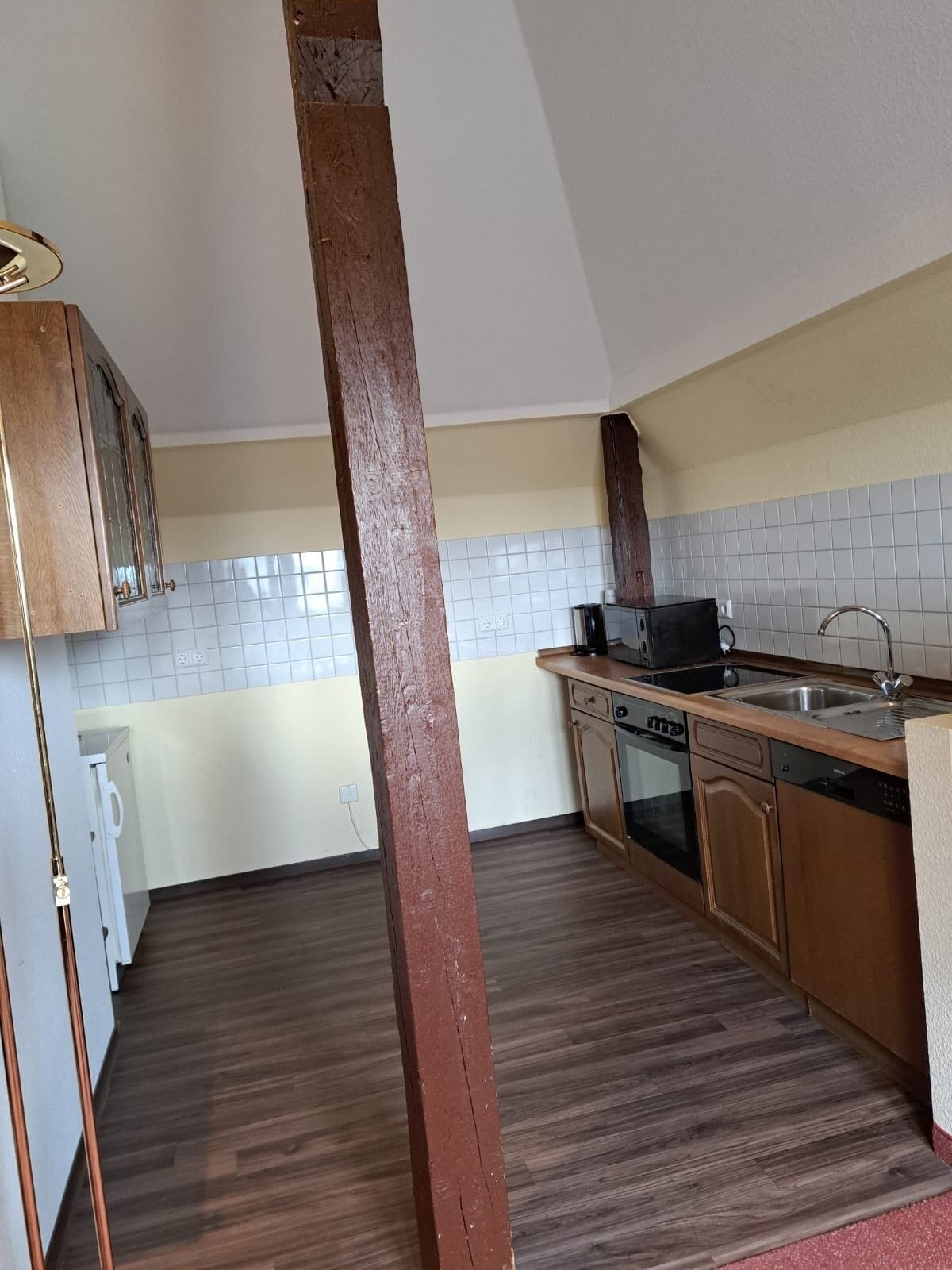 A kitchen with wooden cabinets, a microwave, a dishwasher, and a sink.