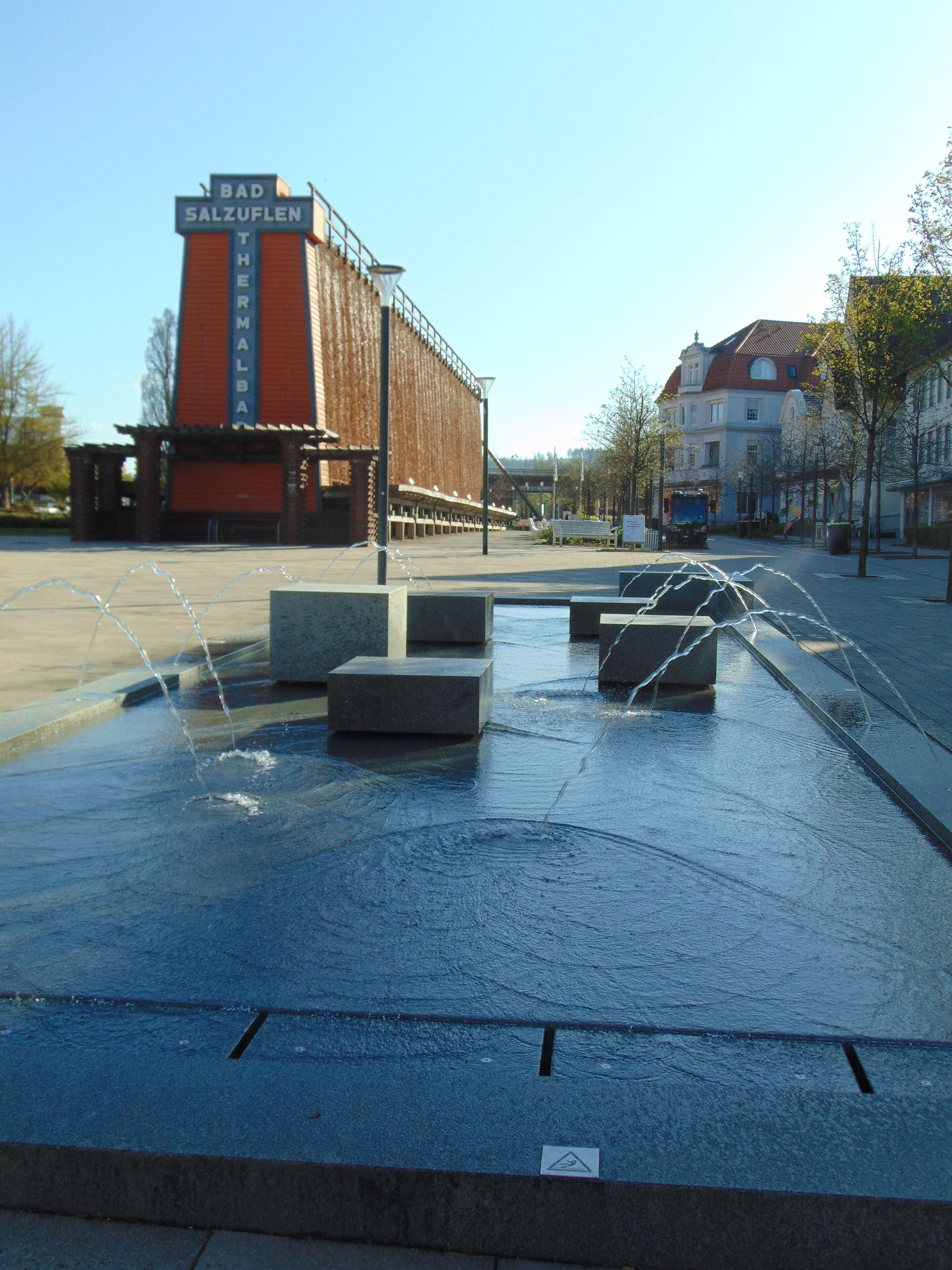 Una plaza pública con una fuente de agua y un edificio con un letrero que dice "BAD SALZUFELN THEMARIK".