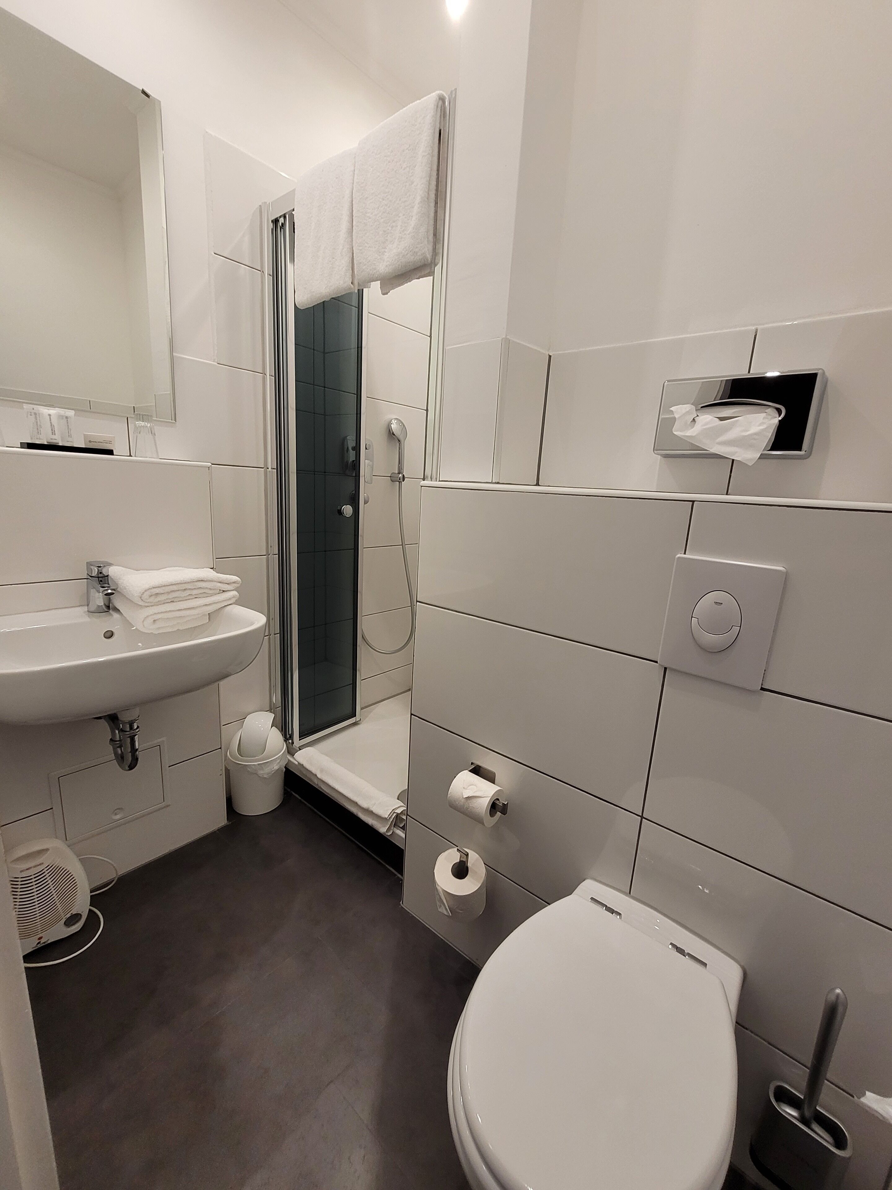 A modern bathroom with a sink, toilet, and shower area.