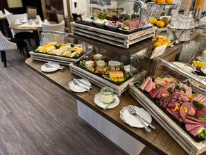 A buffet with various food items including meats, cheeses, and fruits. - Hotel Rosengarten (Bad Salzuflen)