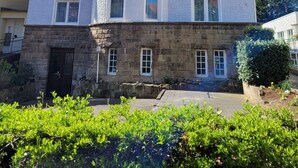 A multi-story building with a stone base and a white upper section, featuring a balcony with a sign reading "Konigin". - Hotel Rosengarten (Bad Salzuflen)