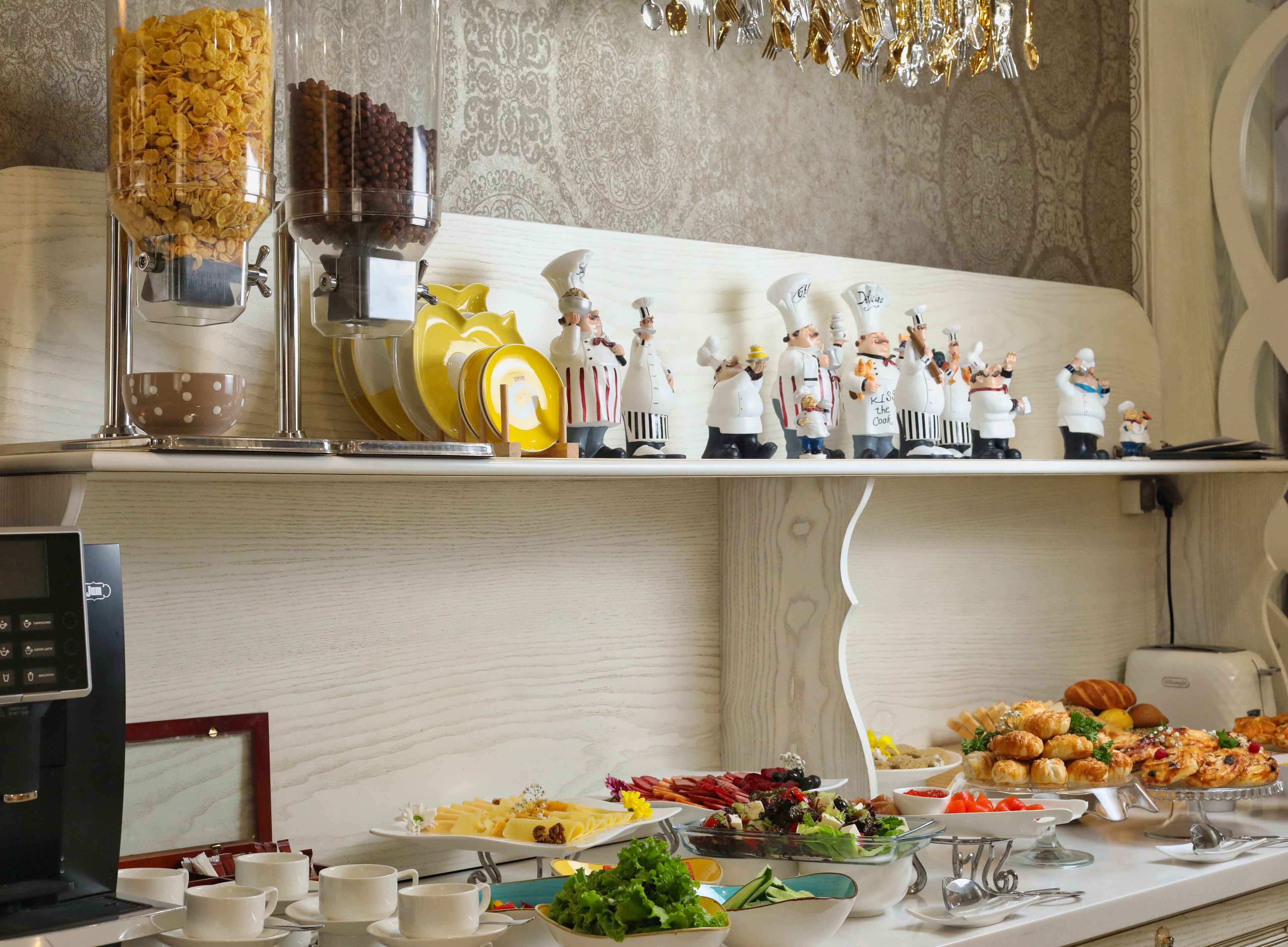 A buffet setup with various food items and a coffee machine.