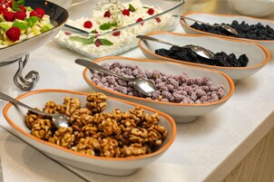 A buffet with various food items including fruits, nuts, and desserts.