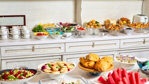 A buffet table with various food items and utensils. - Aster Hotel Group (Tashkent)