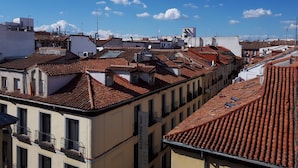 A row of buildings with red-tiled roofs and balconies, likely residential or small commercial properties. - Hostal Casa Chueca (Madrid)