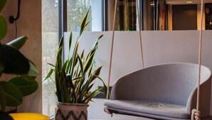 Un interior moderno con un sofá, lámpara colgante y una mesa de vidrio.