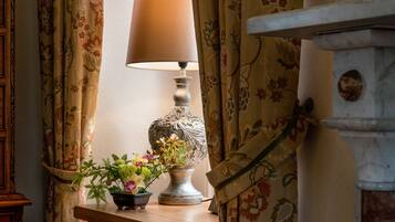 A table with a lamp and a floral arrangement.