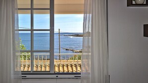 Una ventana con vista al mar y un tejado de tejas.