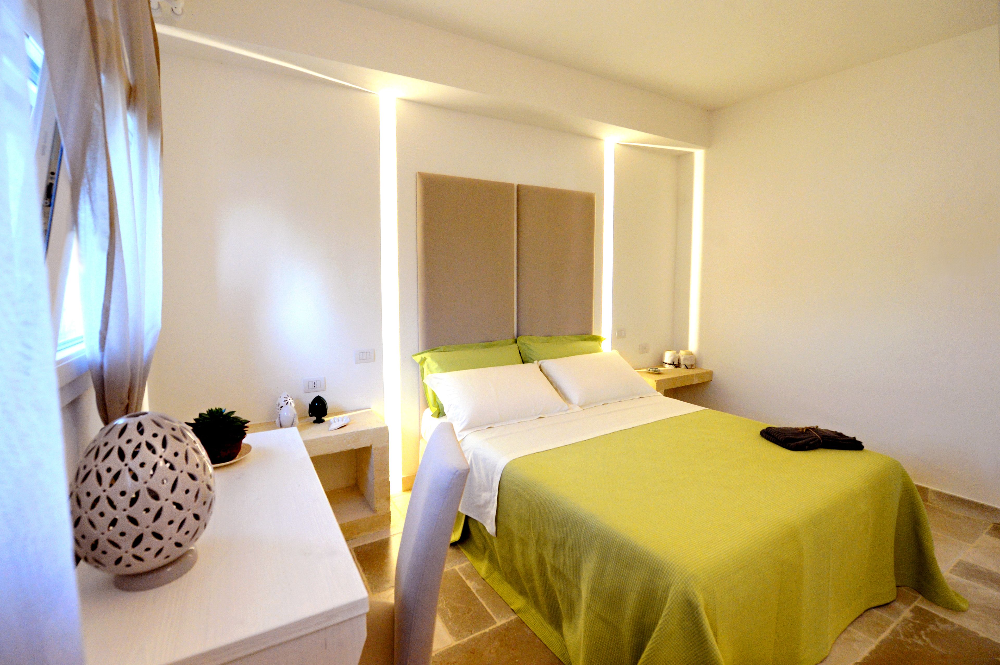 Une chambre d’hôtel avec un lit, une table de chevet, une lampe et un globe décoratif.