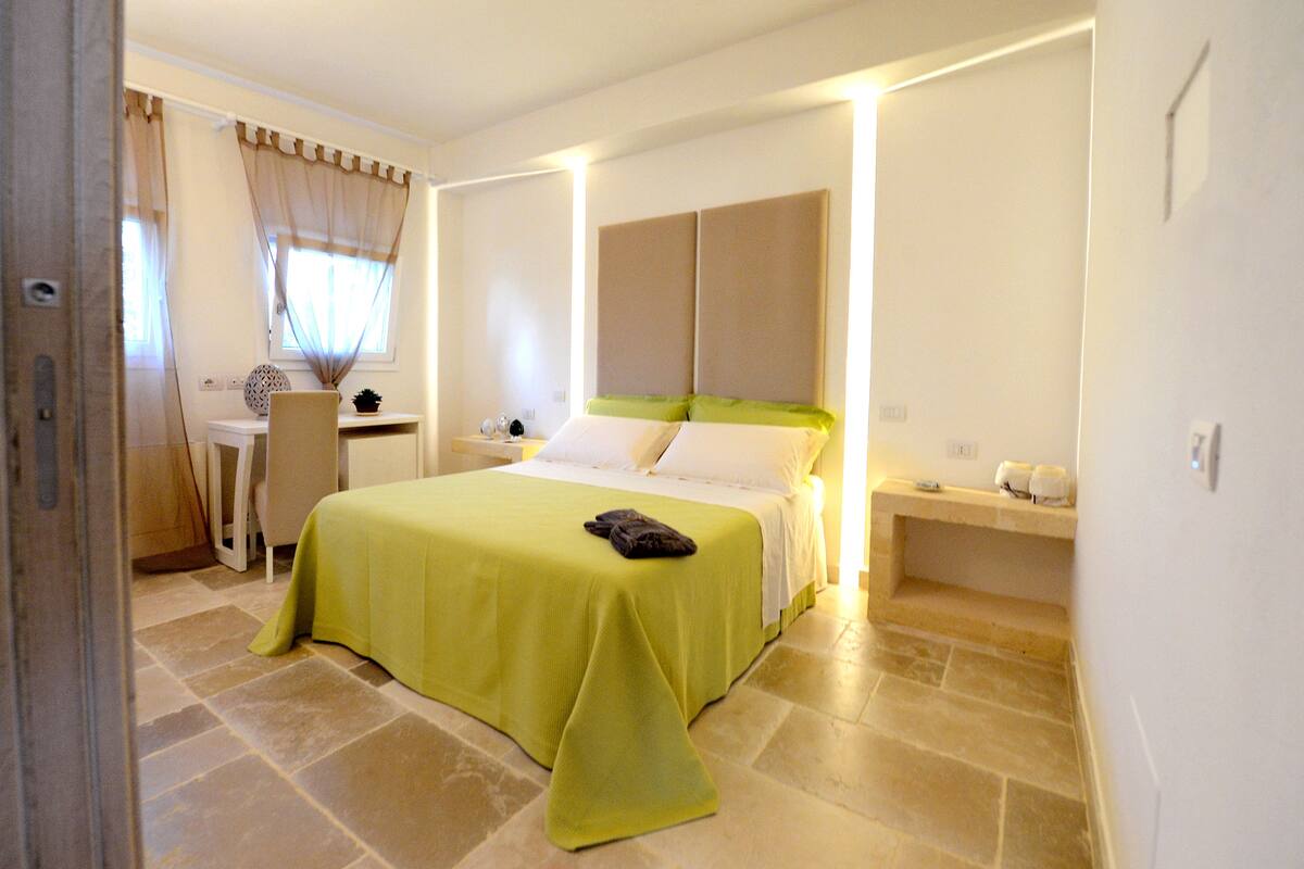 Una habitación de hotel con una cama, un escritorio y una silla.