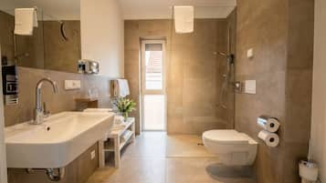 A modern bathroom with a sink, toilet, and shower.