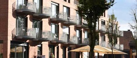 A multi-story building with balconies and outdoor seating areas.
