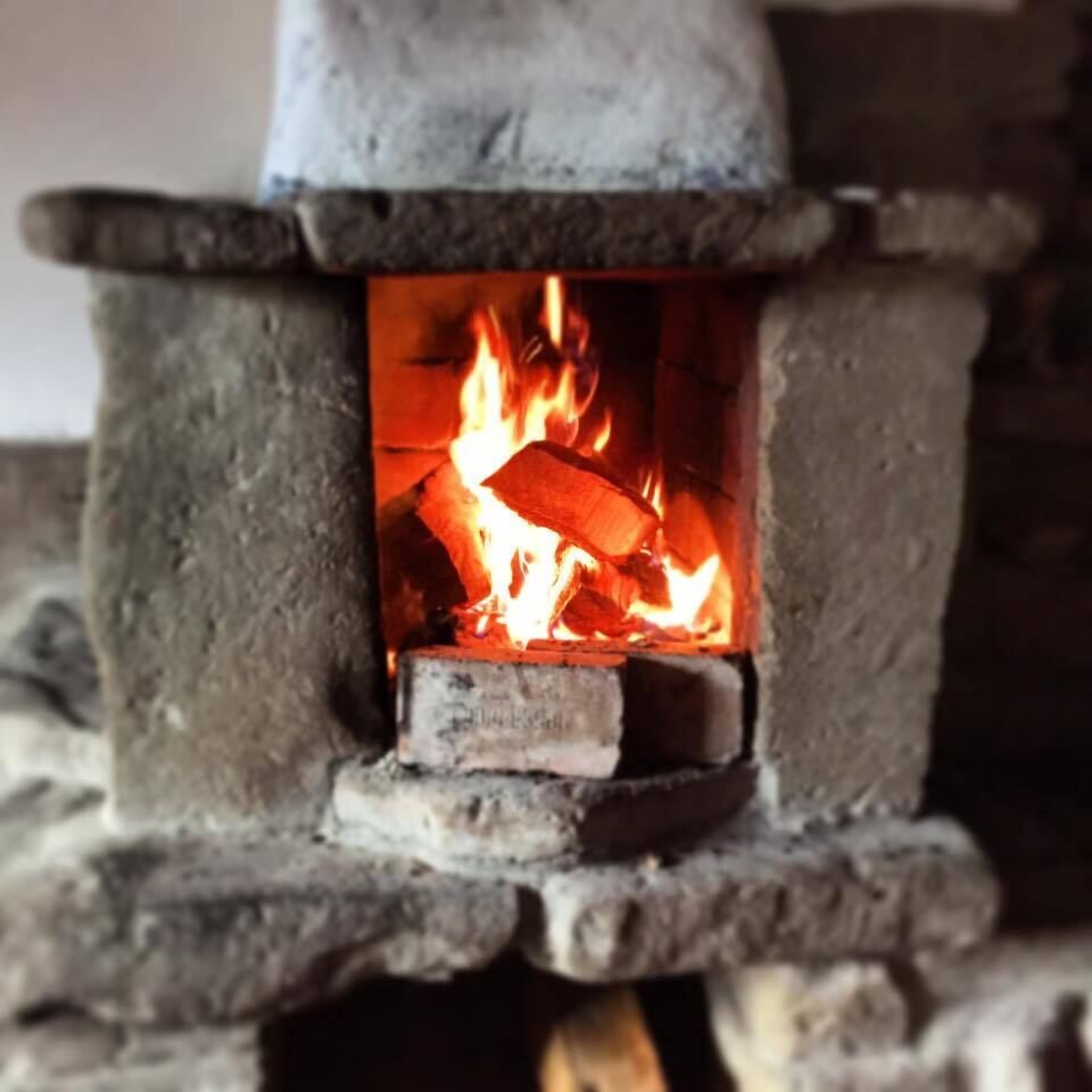 A stone fireplace with a visible fire burning inside.