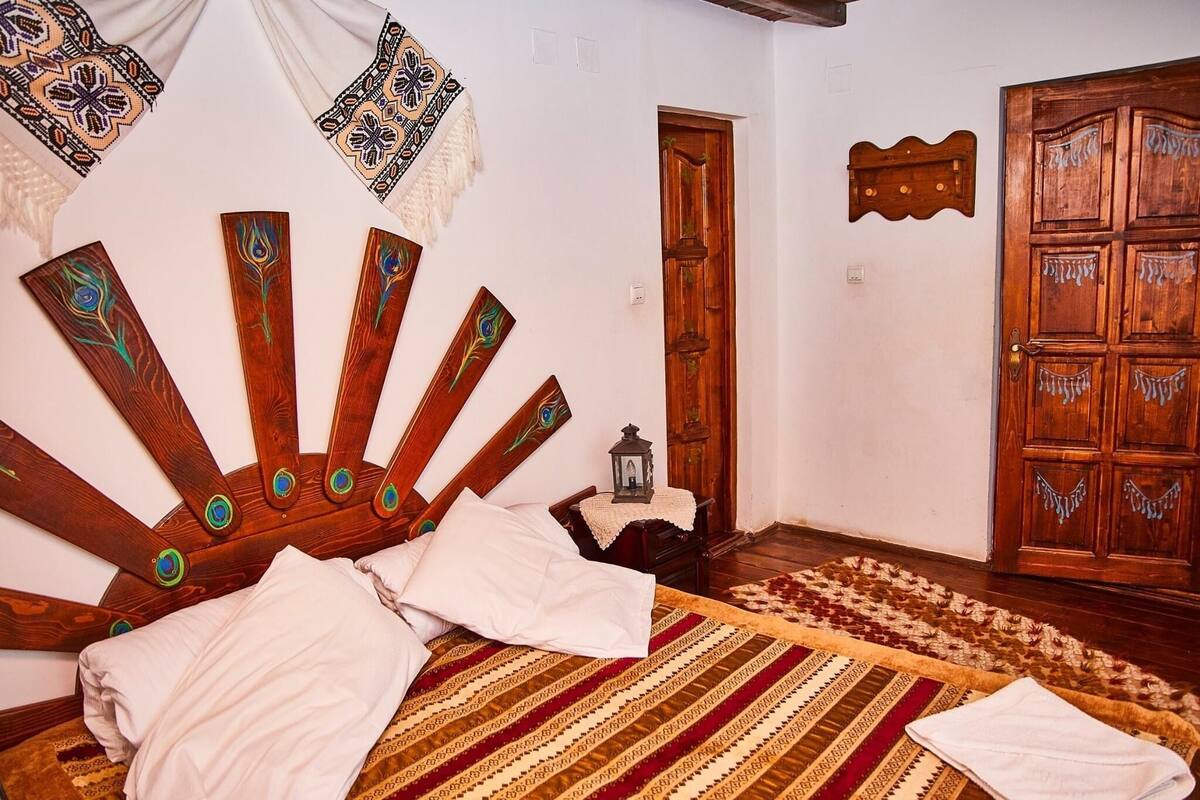 A room with a bed, a wooden door, and a patterned rug.