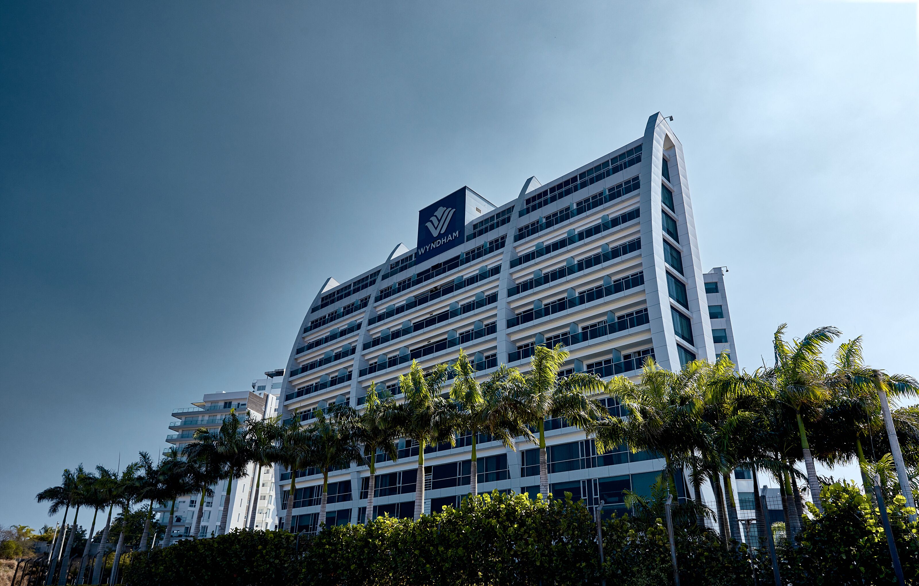 A modern multi-story building with a prominent logo at the top.