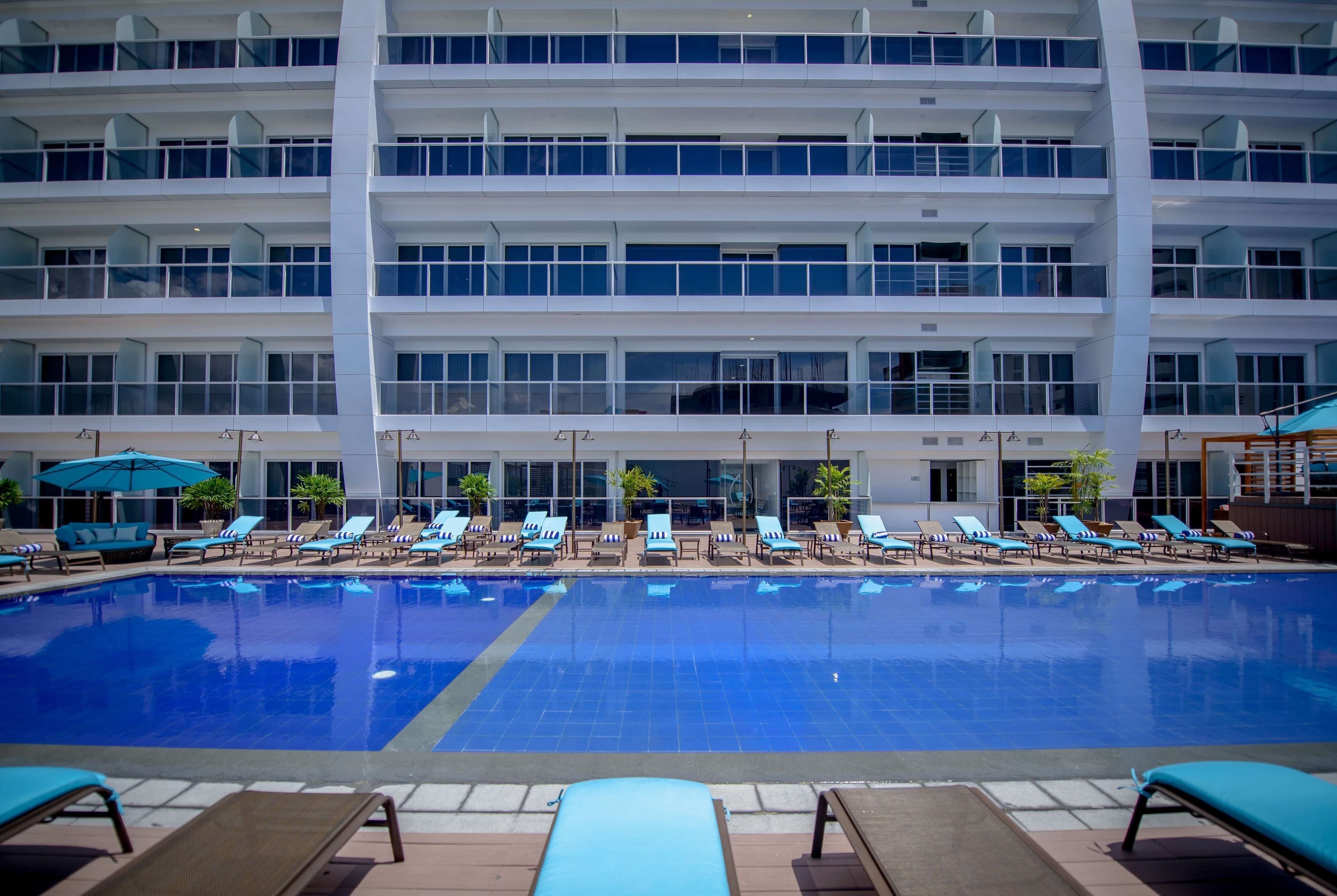 Una amplia piscina interior con varios niveles de balcones y tumbonas.