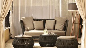 Un salon moderne avec un canapé, deux tables rondes et une lampe sur pied.