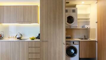 A compact kitchen with wooden cabinets, a built-in washing machine, and a sink.
