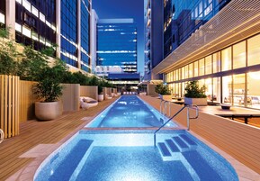 Una piscina al aire libre, sillones reclinables de piscina