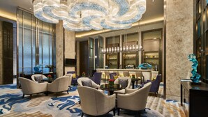 A spacious lobby with a bar area, comfortable seating, and a decorative chandelier. - Wanda Realm Shangrao (Shangrao)