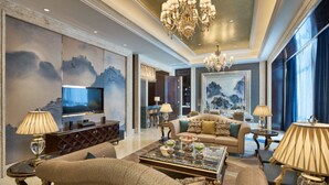 A spacious living room with a large television, comfortable seating, and a chandelier. - Wanda Realm Shangrao (Shangrao)