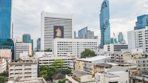 A cityscape with modern high-rise buildings, including a distinctive skyscraper with a unique design. - Tarntawan Place Apartments (Bangkok Noi)