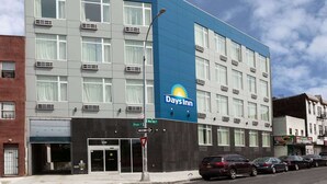 A Days Inn hotel with a blue and grey facade, multiple floors, and a visible entrance with a glass door.