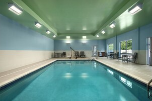Una piscina techada, sillones reclinables de piscina