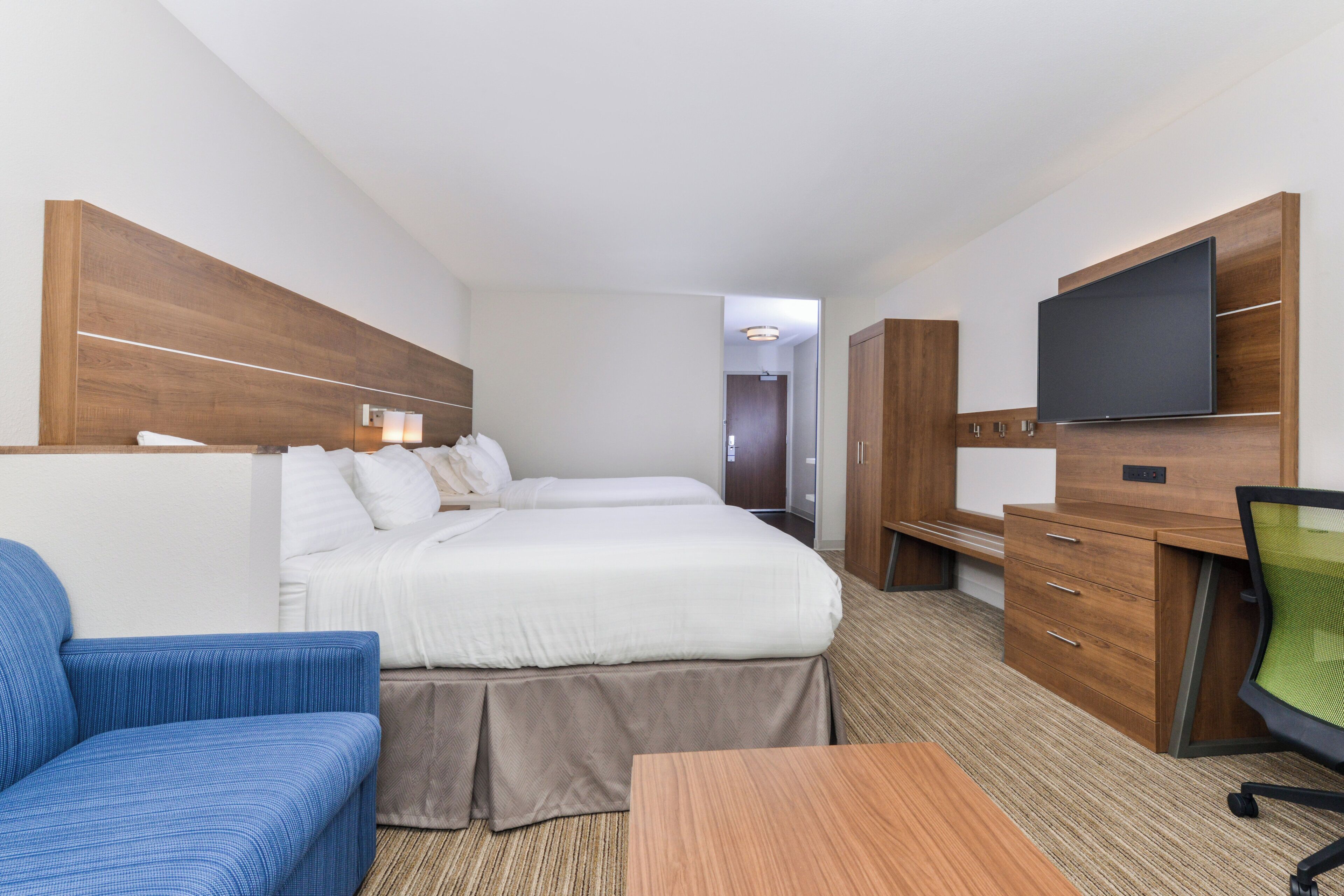 Een hotelkamer met een groot bed, een bureau, een televisie en een zithoek.