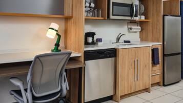 Cocina compacta equipada con microondas, cafetera, lavavajillas y refrigerador.