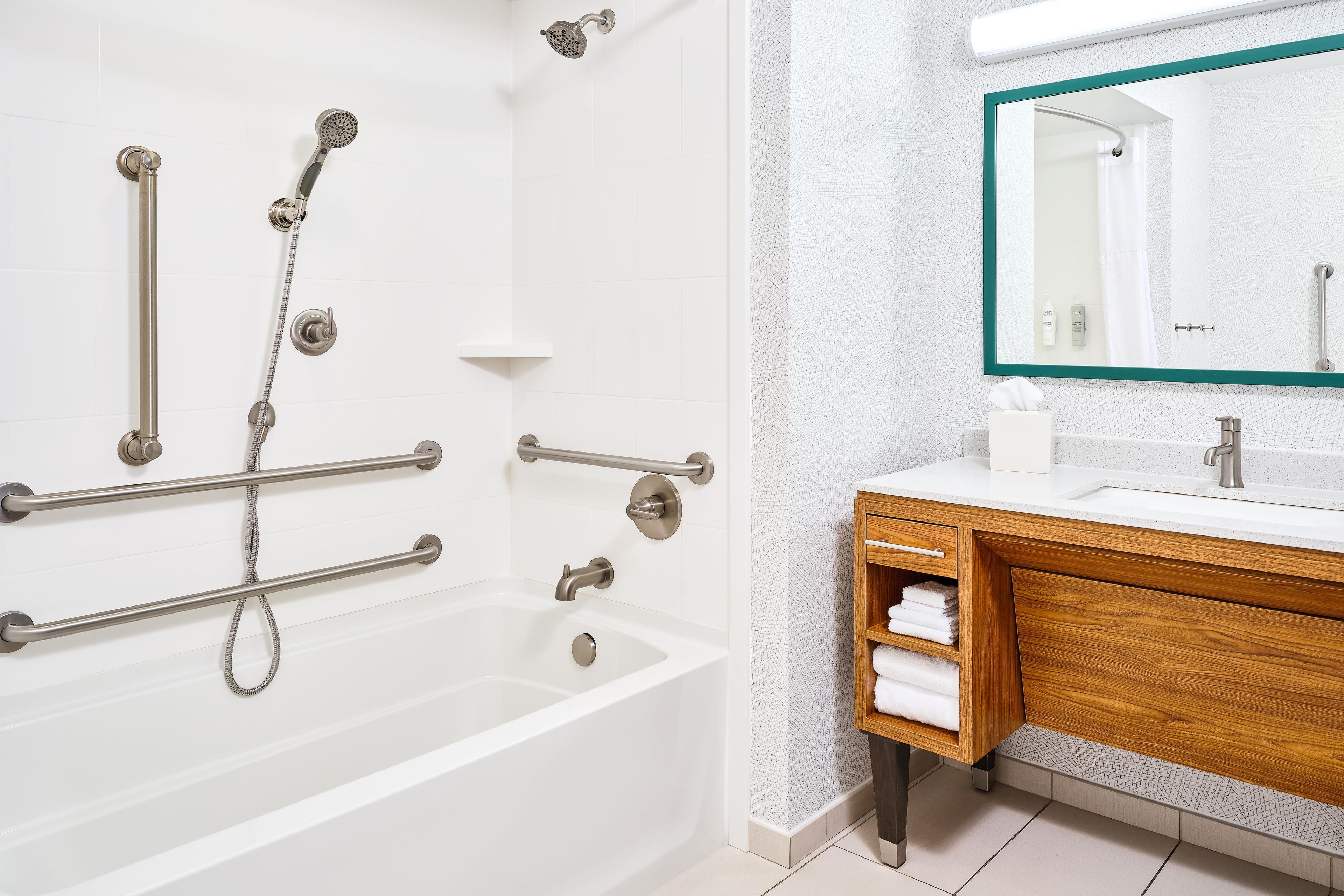 A modern bathroom with a bathtub, shower, and vanity.