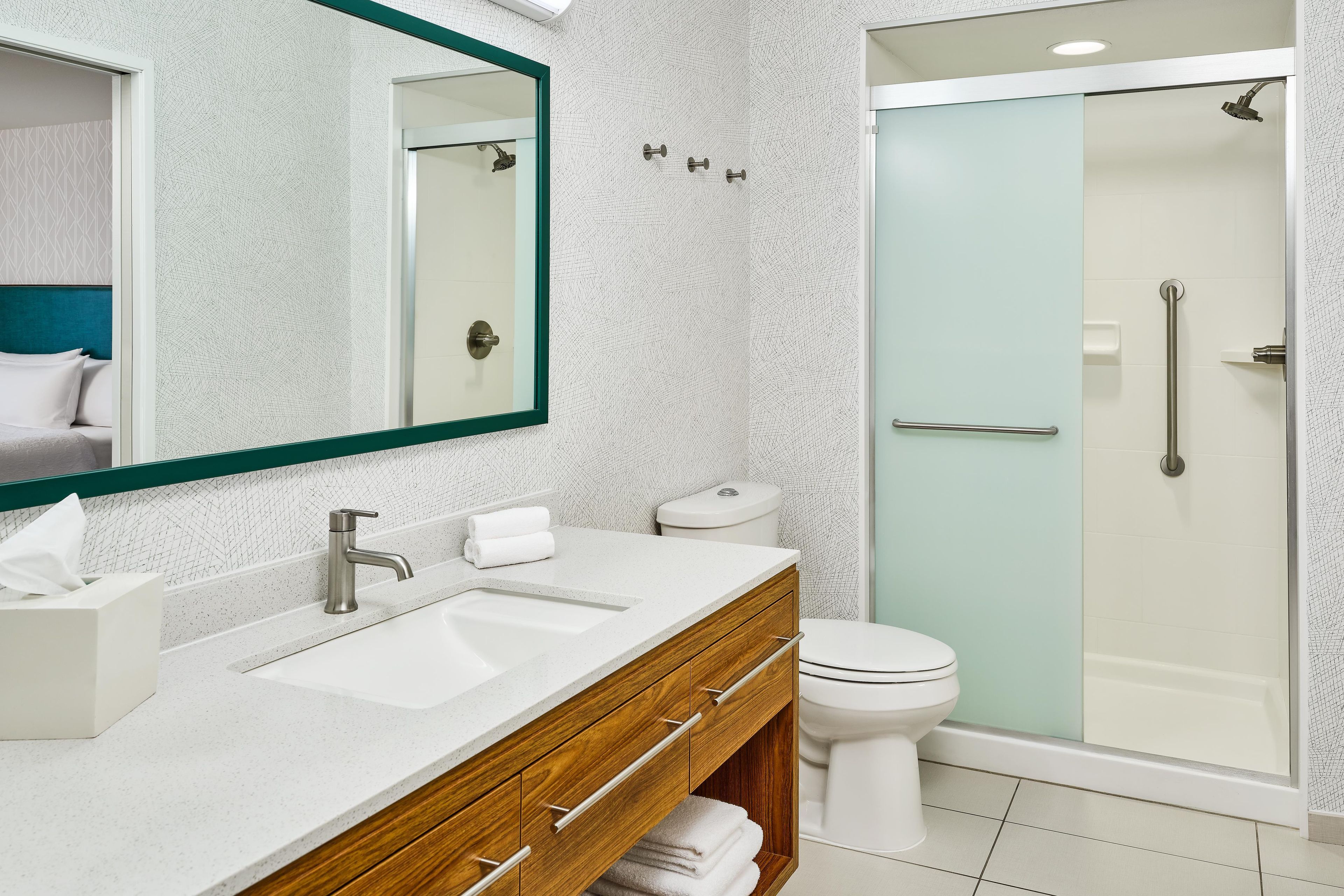 Un baño moderno con un lavamanos doble, un inodoro y una ducha con cerramiento de vidrio.