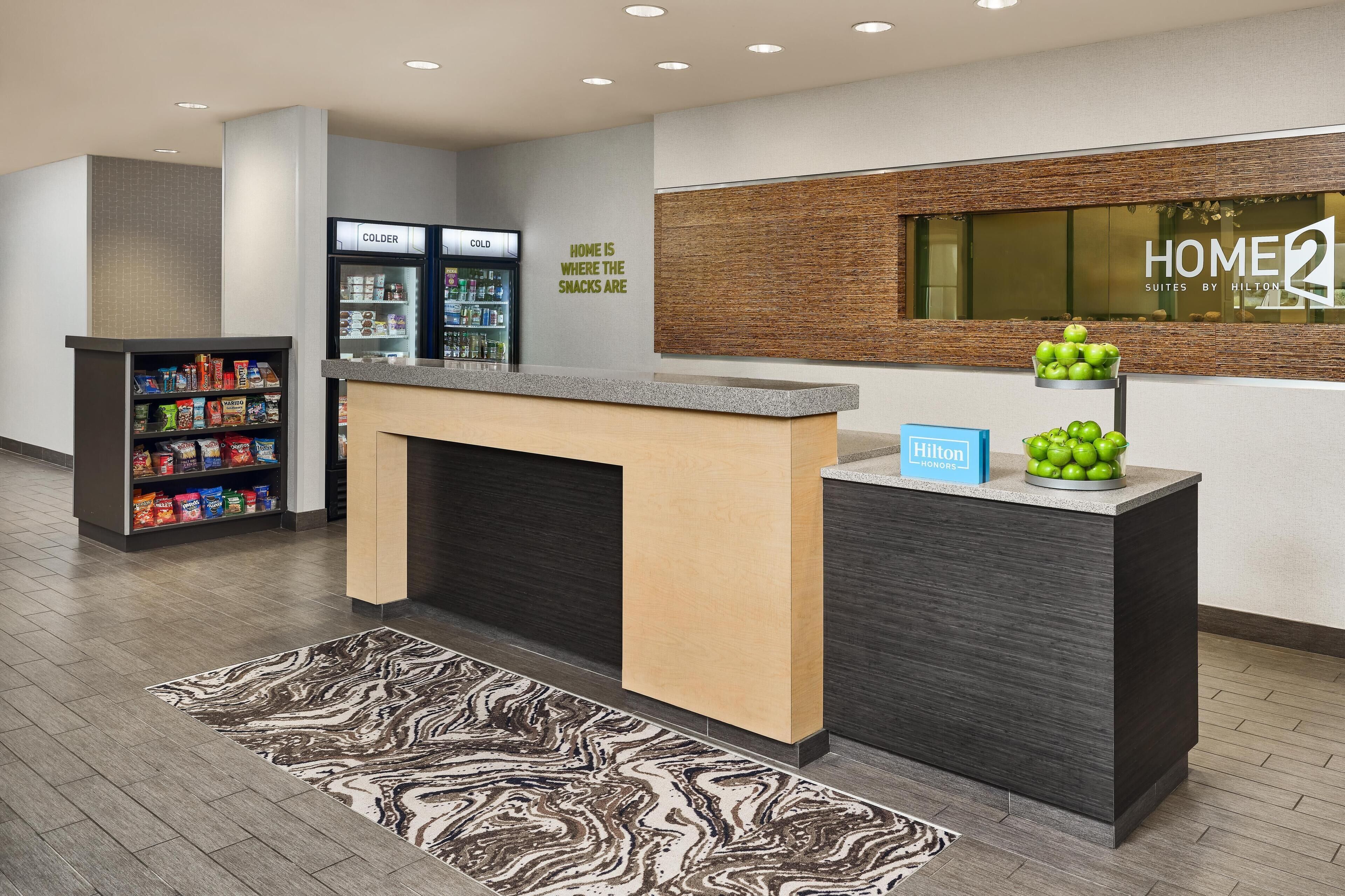 Ein Hotel-Rezeptionsbereich mit Theke, einer Minibar und einem an der Wand befestigten Schild.