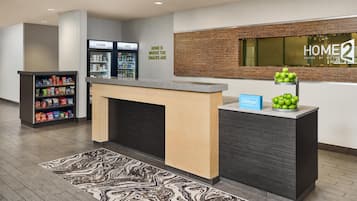 Ein Hotel-Rezeptionsbereich mit Theke, einer Minibar und einem an der Wand befestigten Schild.