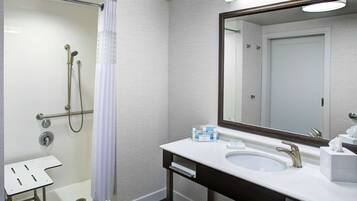 A modern bathroom with a shower, a sink, and a mirror.