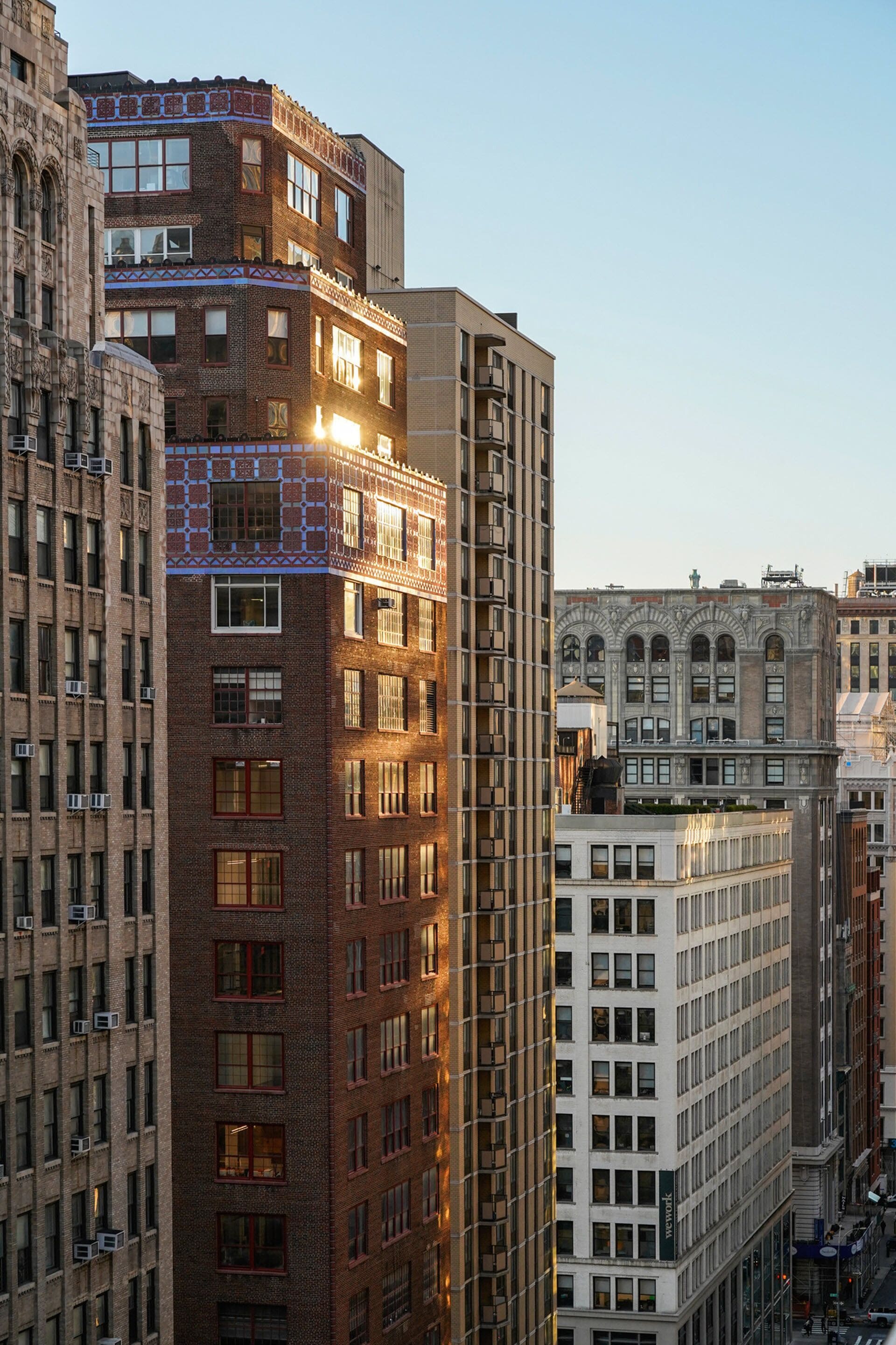 A multi-story building with a mix of architectural styles, including brick and white facades, and multiple windows.