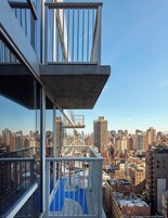 Un edificio alto con balcón de cristal que ofrece vistas a la ciudad.