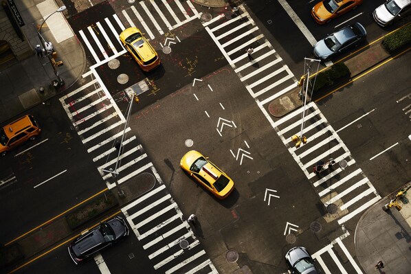 Vista aérea de una intersección urbana con múltiples carriles, semáforos y vehículos.