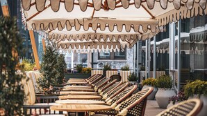 Outdoor seating with umbrellas, potted plants, and a view of the city. - Hotel Park Ave NYC (New York)