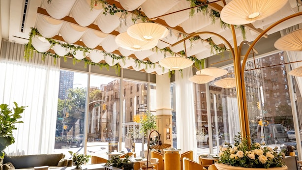 A modern interior with large windows, a seating area with sofas and chairs, and hanging lamps with greenery. - Hotel Park Ave NYC (New York)
