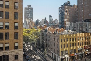 Una calle urbana con edificios, incluyendo un edificio amarillo con escaparate.