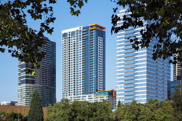 A high-rise building with a distinctive orange top, surrounded by other tall buildings and trees.