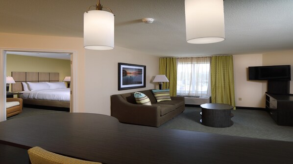 A hotel room with a bed, a sofa, a TV, and a desk.