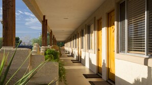 Un corridoio con porte, finestre e pavimento in cemento.