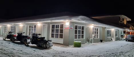 Een gebouw bedekt met sneeuw, met een bordje dat een motelkantoor aangeeft.