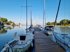 A marina with multiple sailboats docked along a wooden pier. - Manor Motel (Saugeen Shores)