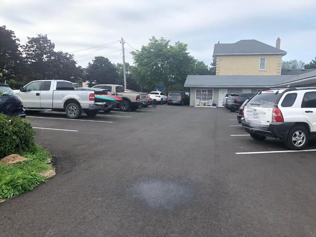 Un parking où sont stationnés plusieurs véhicules, notamment des camions et des voitures.