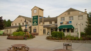 A building with a clock tower, outdoor seating, and a sign welcoming visitors. - Club Wyndham Smugglers’ Notch Vermont  (Jeffersonville)