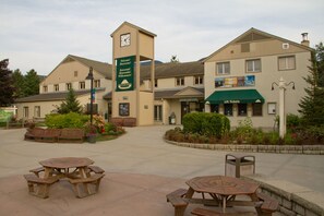 A building with a clock tower, outdoor seating, and a sign welcoming visitors. - Club Wyndham Smugglers’ Notch Vermont  (Jeffersonville)